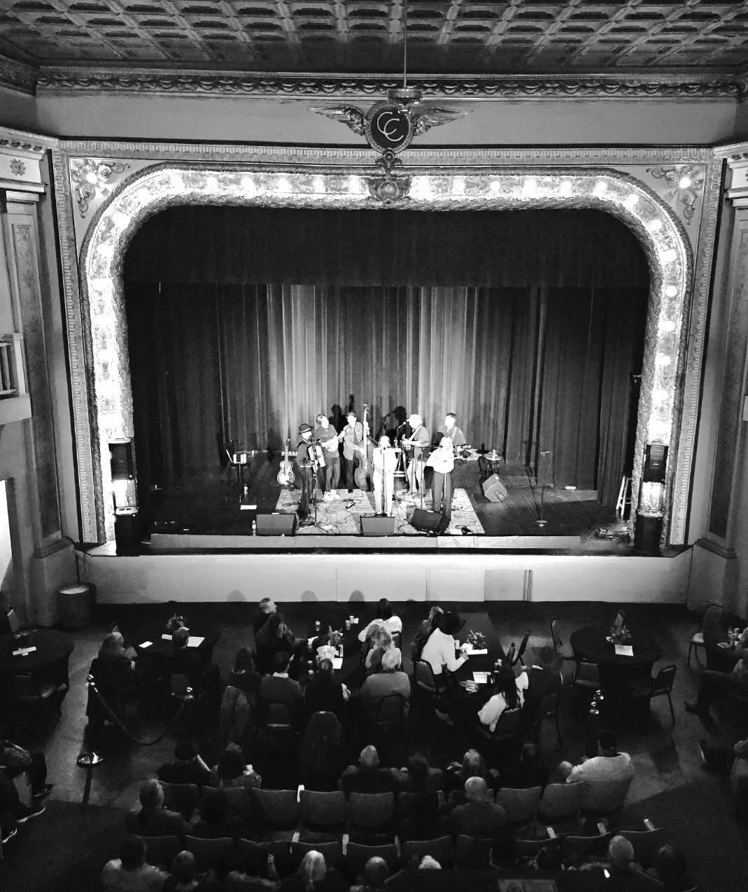 Constantine Theater interior — band performing on the ornate stage with a full audience